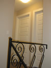 Hallway is completed with new wrought iron railings, fresh paint and new lighting